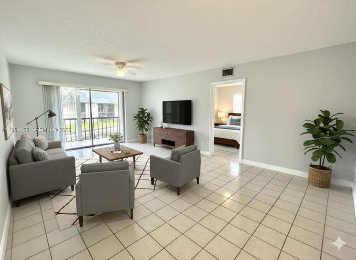 8020 North Colony Circle, Unit 203 Tamarac, FL 33321 - Photo 4 of 13 a living room with furniture and a flat screen tv