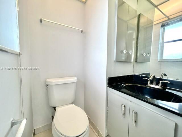 8020 North Colony Circle, Unit 203 Tamarac, FL 33321 - Photo 8 of 13 a bathroom with a sink a toilet and a mirror