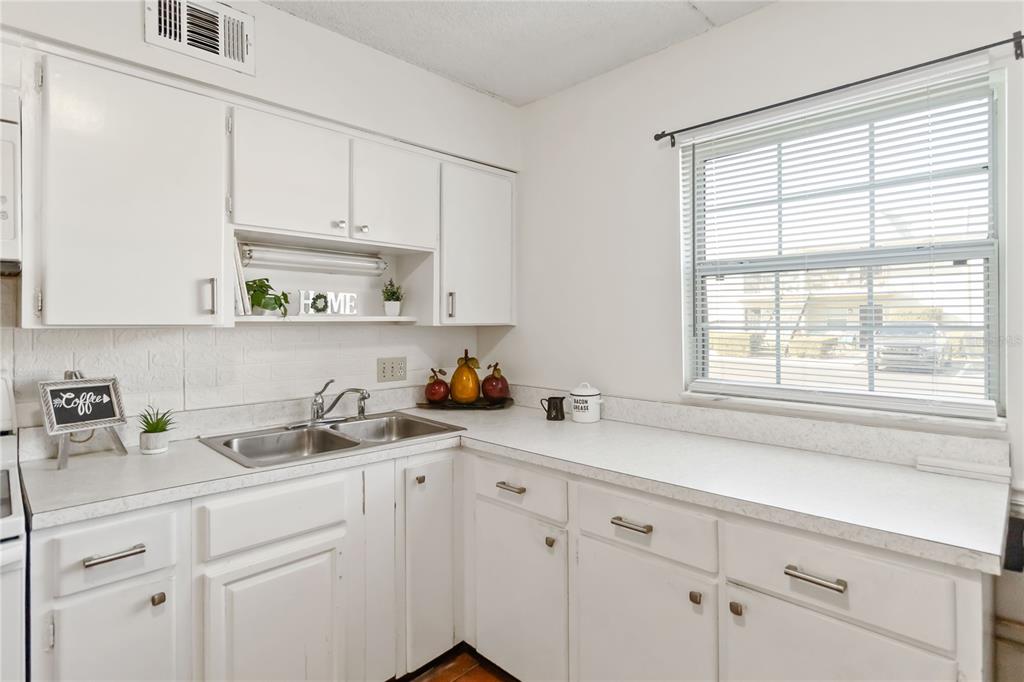 525 South Conway Road, Unit 29 Orlando, FL 32807 - Photo 16 of 29 a kitchen with white cabinets and a window