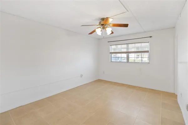 an empty room with windows and fan