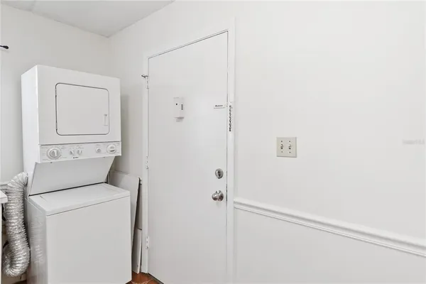 an empty room with a chandelier fan and window