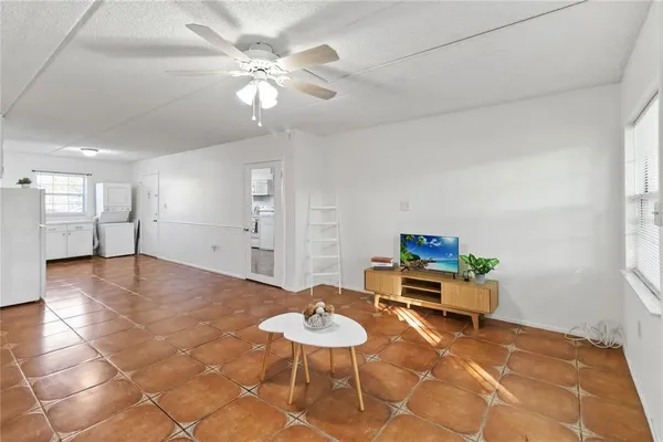 a living room with furniture and a dining table with kitchen view