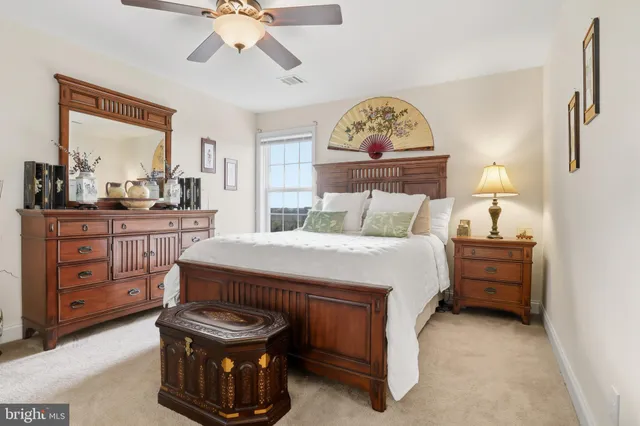 a bedroom with a bed a couch and a chandelier