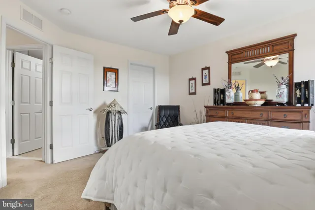 a bedroom with a bed and a flat tv screen on the dresser