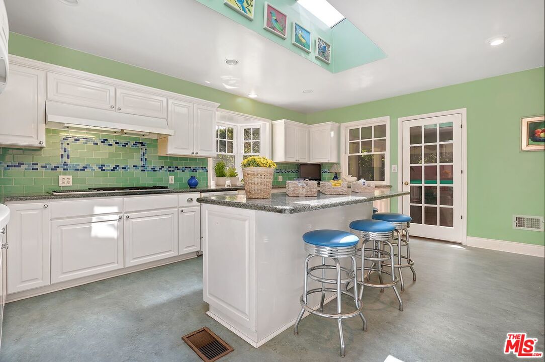 208 South Plymouth Boulevard Los Angeles, CA 90004 - Photo 21 of 44 a kitchen with kitchen island granite countertop a sink and white cabinets
