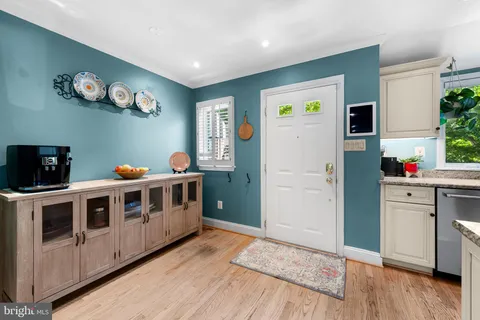 a kitchen with a stove a refrigerator and a wooden floor