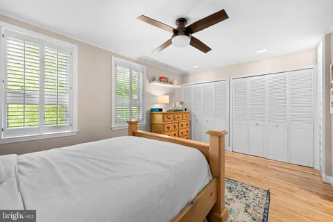 a bedroom with a bed next to a window and a chandelier