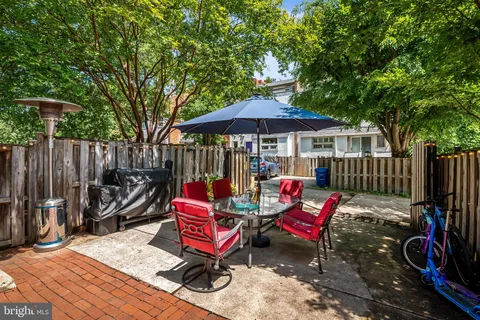 a view of a chairs and table in patio with wooden fence