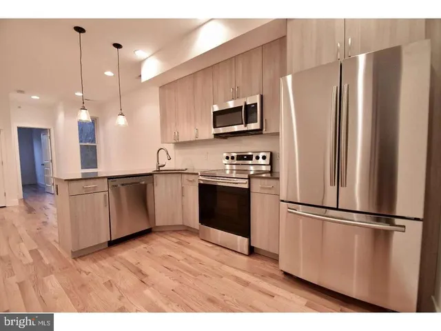 a kitchen with stainless steel appliances a refrigerator sink and microwave