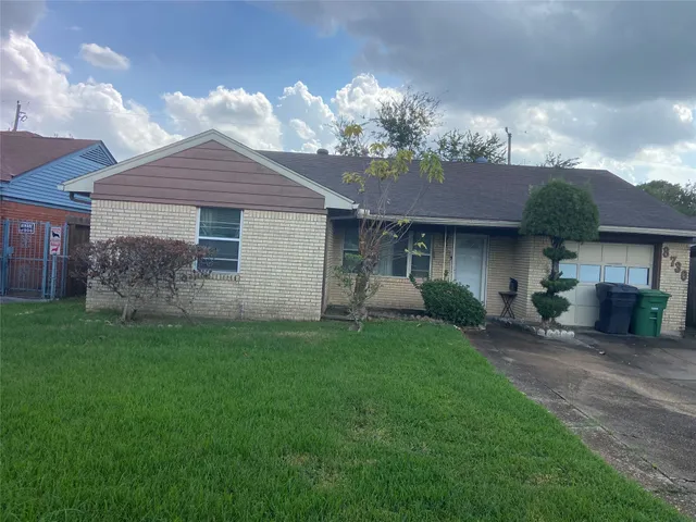 a front view of a house with a garden and yard