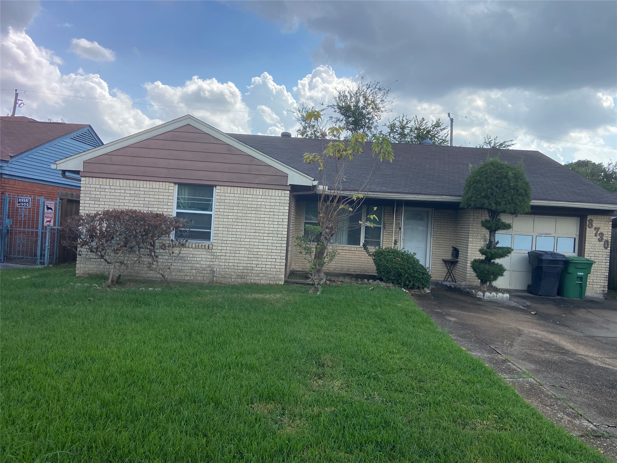 a front view of a house with a garden and yard
