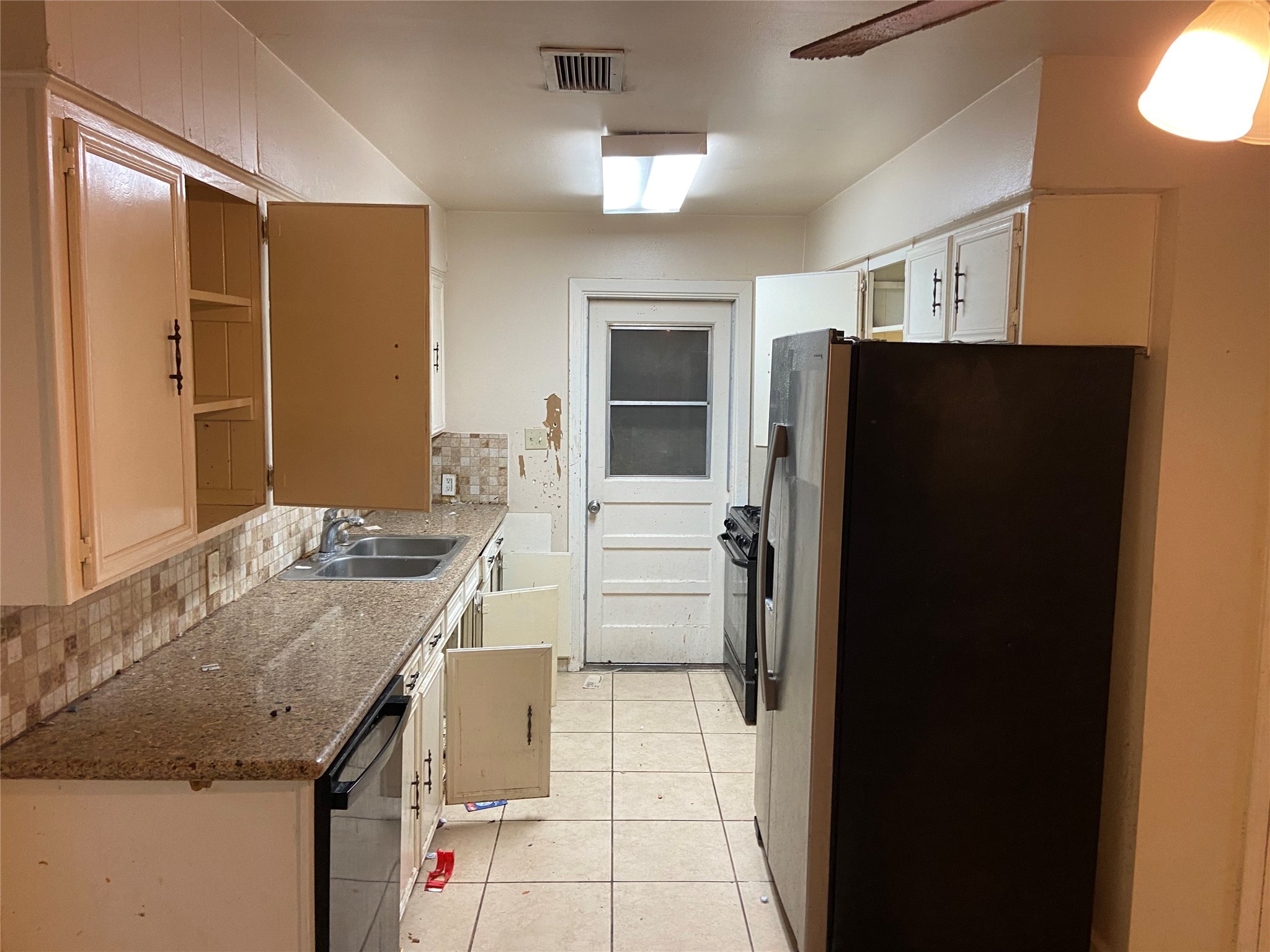 8730 Cowart Street Houston, TX 77029 - Photo 2 of 25 a kitchen with a refrigerator and a sink