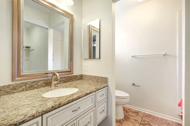 a bathroom with a granite countertop sink toilet and shower
