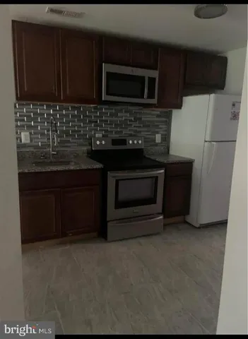 a kitchen with stainless steel appliances wooden cabinets and a stove top oven