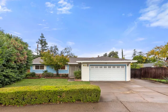 a view of a house with a yard and a garage
