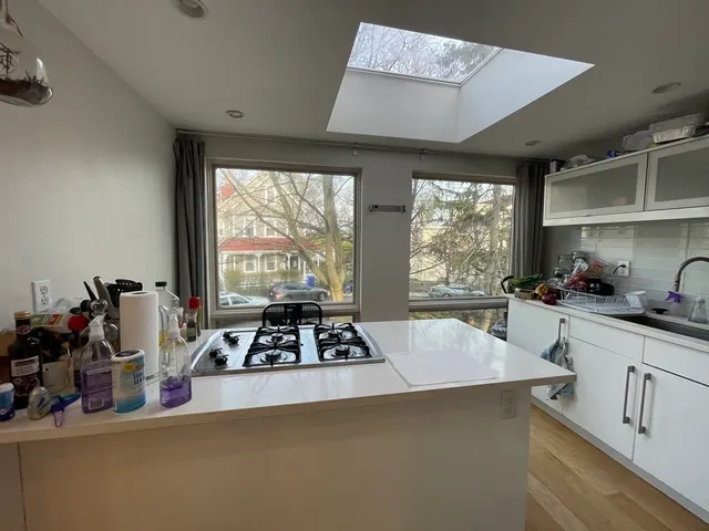 a kitchen with sink a window and cabinets