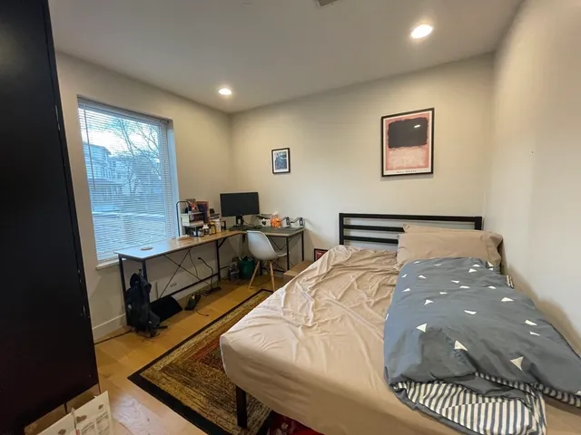 a bedroom with a bed and wooden floor