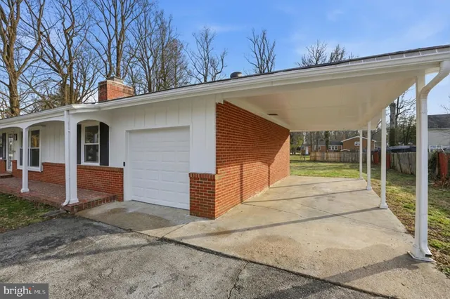 a view of a white house with large windows and wooden fence