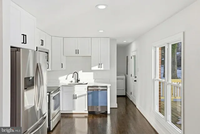 a kitchen with kitchen island a refrigerator sink and cabinets