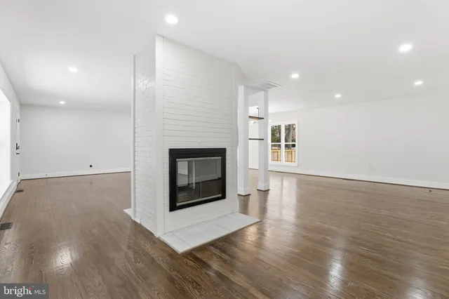 an empty room with wooden floor and fireplace