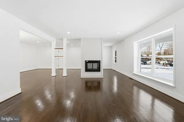 a view of a living room a kitchen with wooden floor and a window
