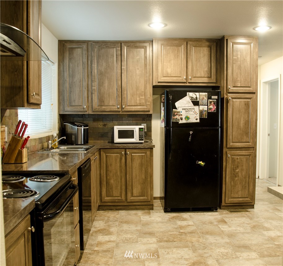 6510 Skinner Road Granite Falls, WA 98252 - Photo 11 of 19 a kitchen with a refrigerator stove and cabinets