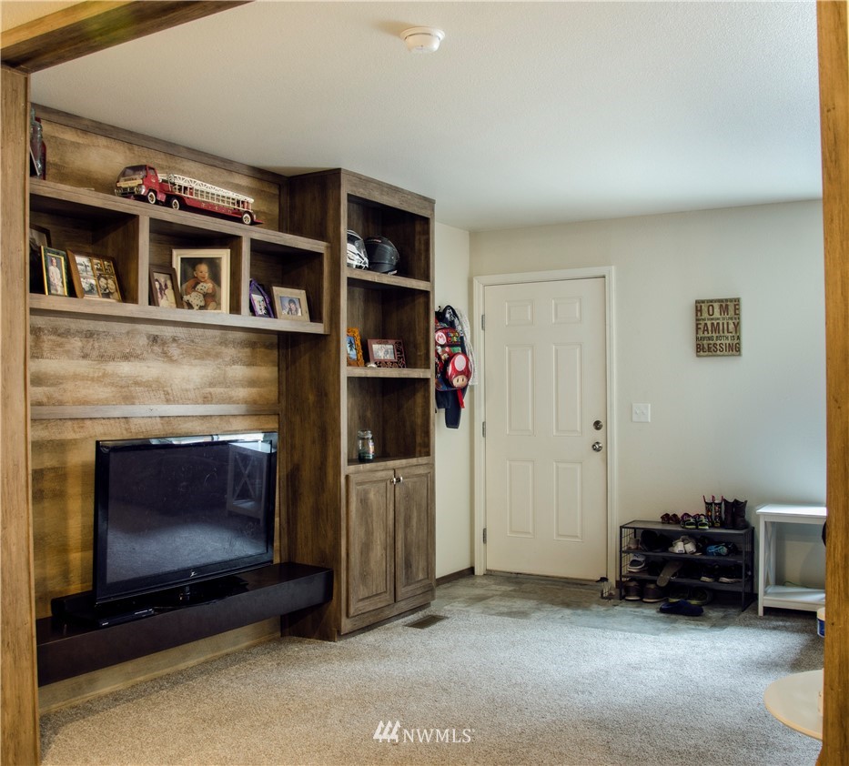 6510 Skinner Road Granite Falls, WA 98252 - Photo 5 of 19 a living room with furniture a flat screen tv and a fireplace