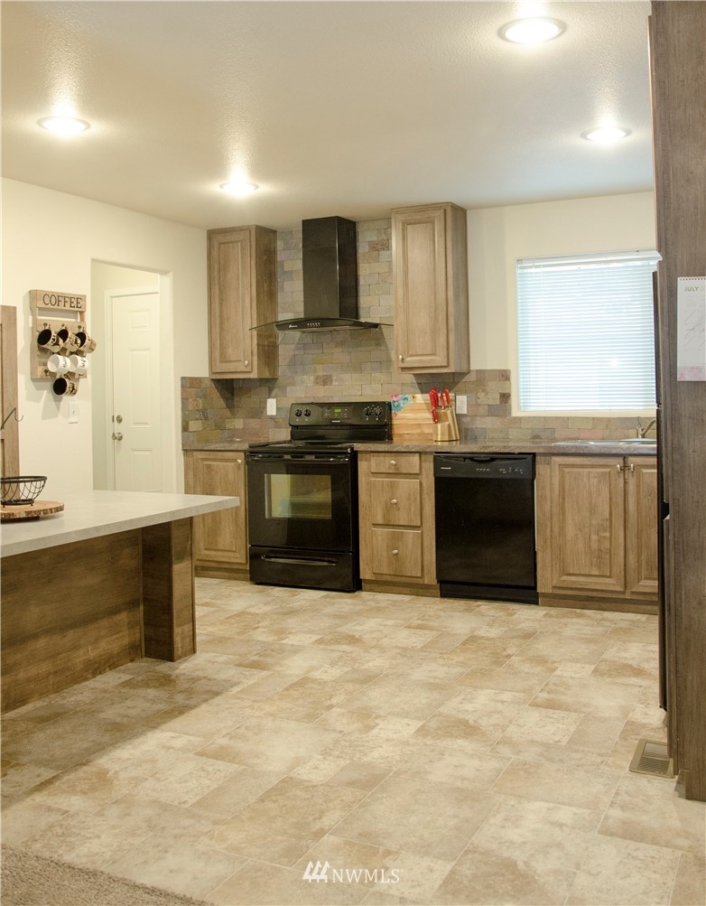 6510 Skinner Road Granite Falls, WA 98252 - Photo 8 of 19 a large kitchen with stainless steel appliances granite countertop a stove a sink dishwasher and a refrigerator