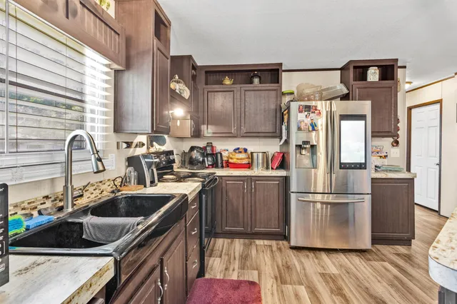 a kitchen with wooden cabinets a sink and a refrigerator
