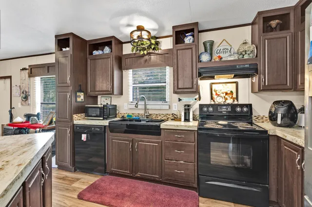 a kitchen with stainless steel appliances granite countertop a stove sink and cabinets
