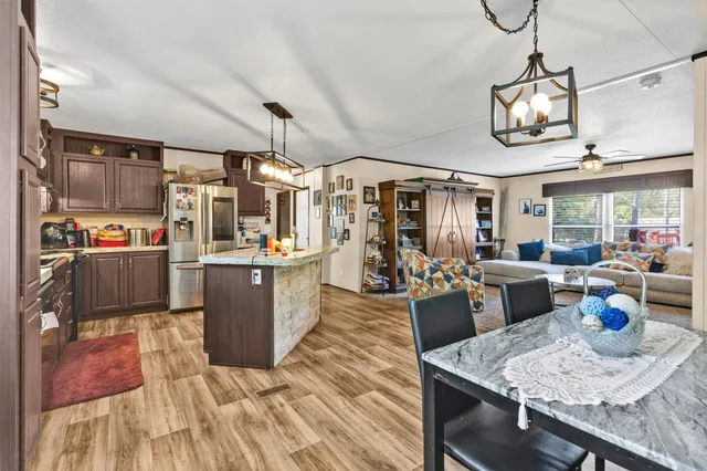 a kitchen view of a dining table chairs and refrigerator