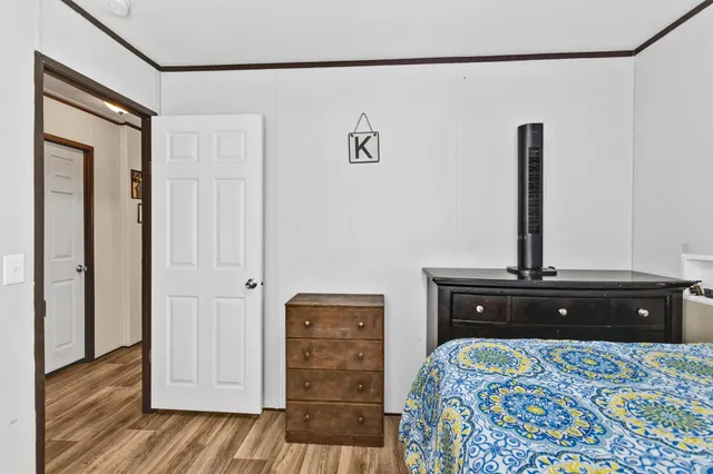 a bedroom with a bed and wooden floor