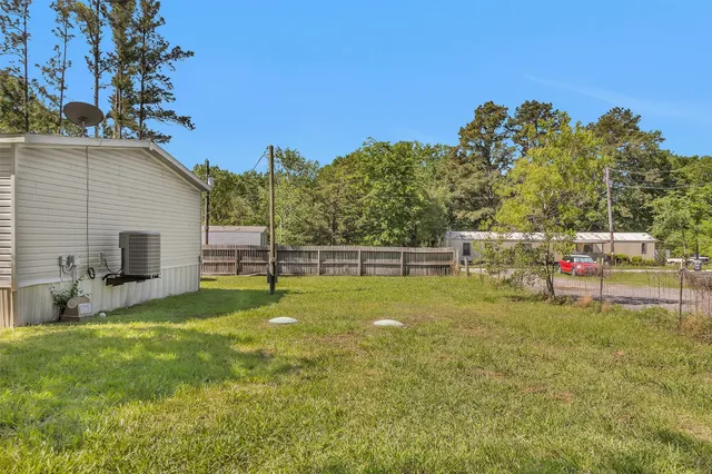 a view of a backyard with couches plants and large tree