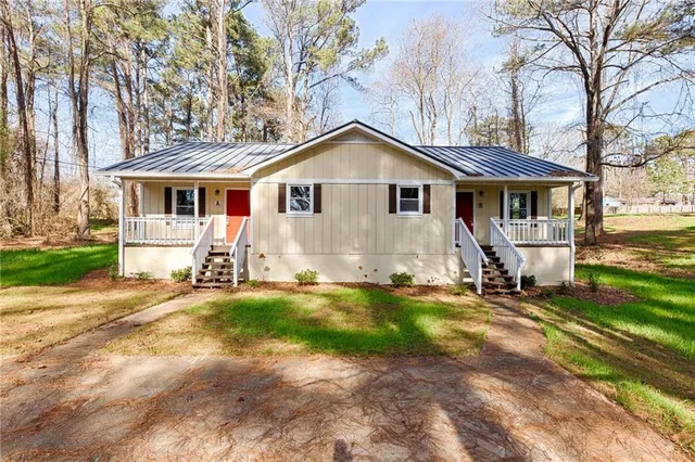 a view of a house with backyard and trees