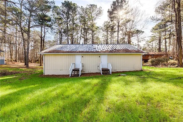 a view of a house with a backyard and tree
