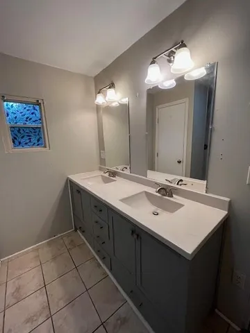 a bathroom with a sink vanity and a mirror