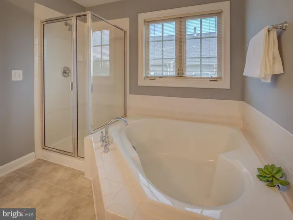 a kitchen with stainless steel appliances granite countertop a refrigerator a sink dishwasher a stove and white countertops with wooden floor