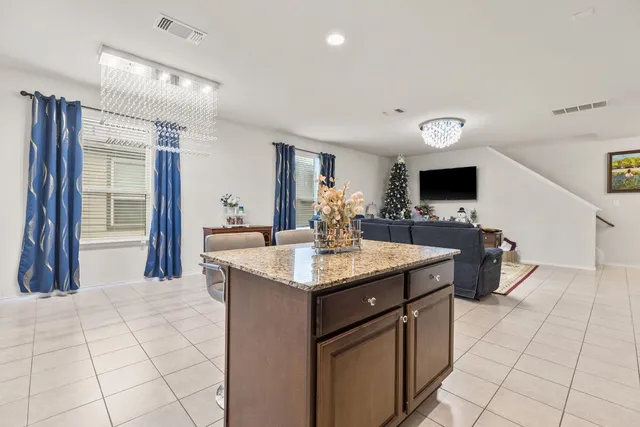 a kitchen with stainless steel appliances granite countertop a stove a sink a microwave a refrigerator and a cabinets