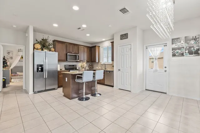 a kitchen with a sink a counter top space appliances and a center island