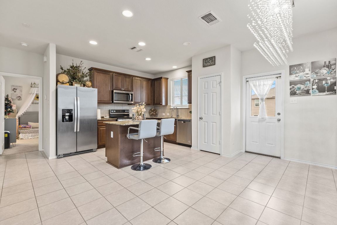 209 Ibis Falls Loop Jarrell, TX 76537 - Photo 16 of 40 a kitchen with stainless steel appliances a refrigerator sink and cabinets