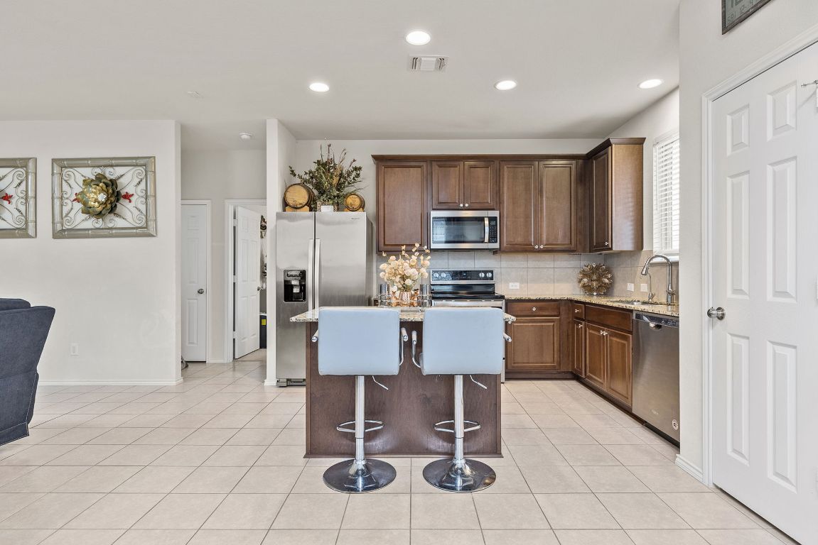 209 Ibis Falls Loop Jarrell, TX 76537 - Photo 17 of 40 a kitchen with stainless steel appliances granite countertop a stove a sink a microwave a refrigerator and a cabinets