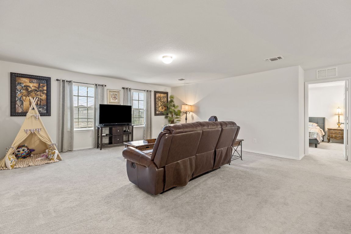 209 Ibis Falls Loop Jarrell, TX 76537 - Photo 23 of 40 a living room with furniture and a flat screen tv