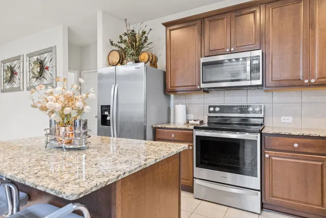 a kitchen with stainless steel appliances granite countertop a stove a microwave and a refrigerator