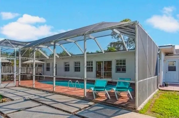 a view of a chair and table in backyard of the house