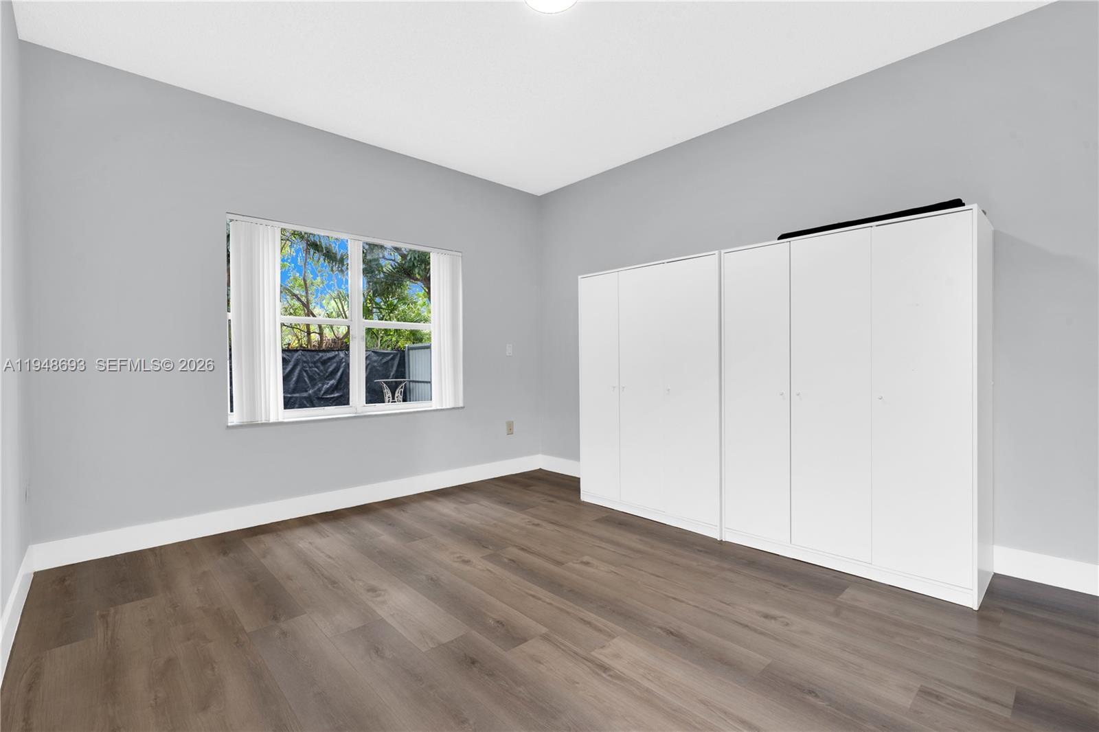 74 Northwest 2nd Street Homestead, FL 33030 - Photo 13 of 41 an empty room with wooden floor and windows