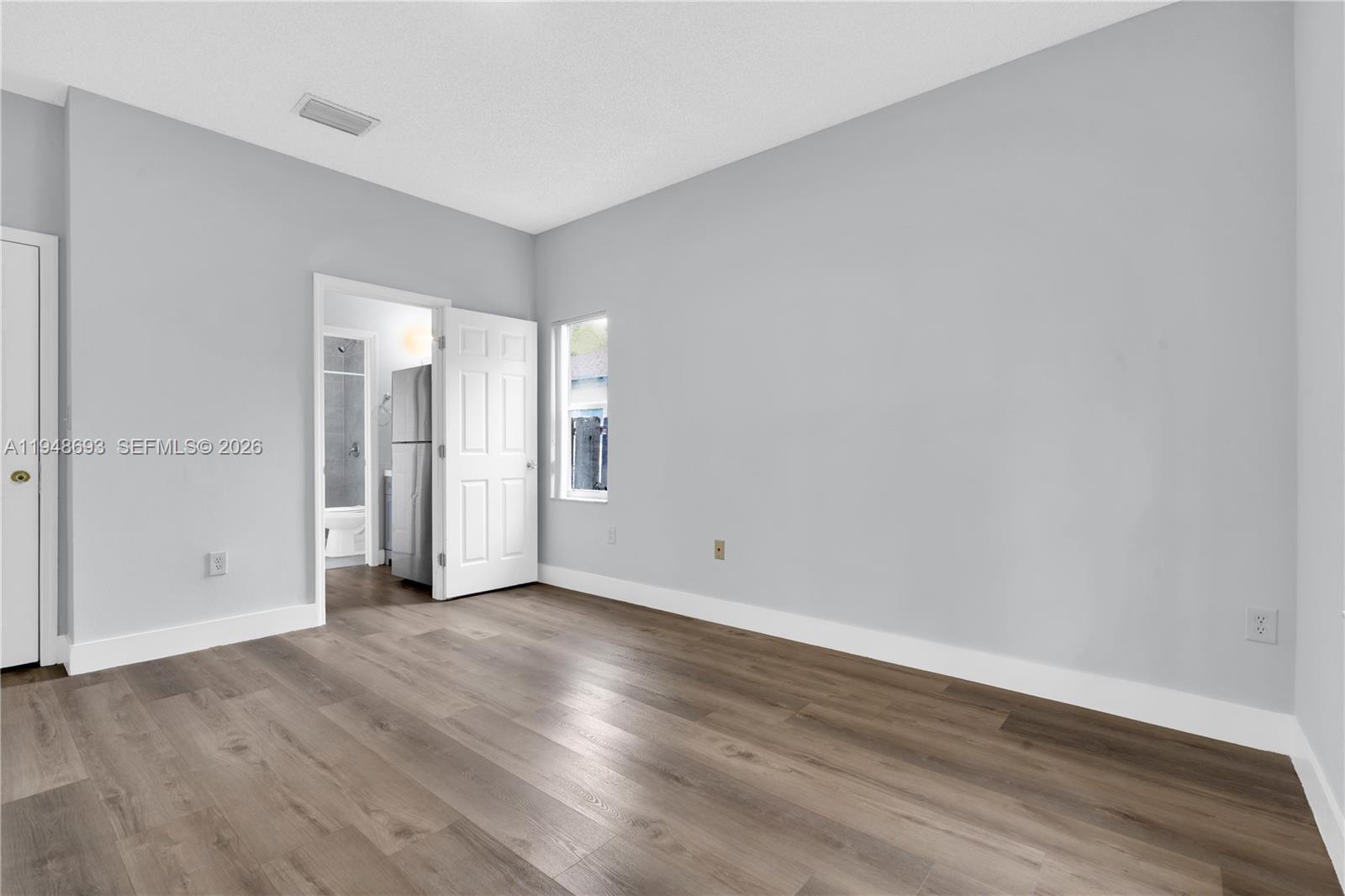 74 Northwest 2nd Street Homestead, FL 33030 - Photo 14 of 41 a view of an empty room with wooden floor and window