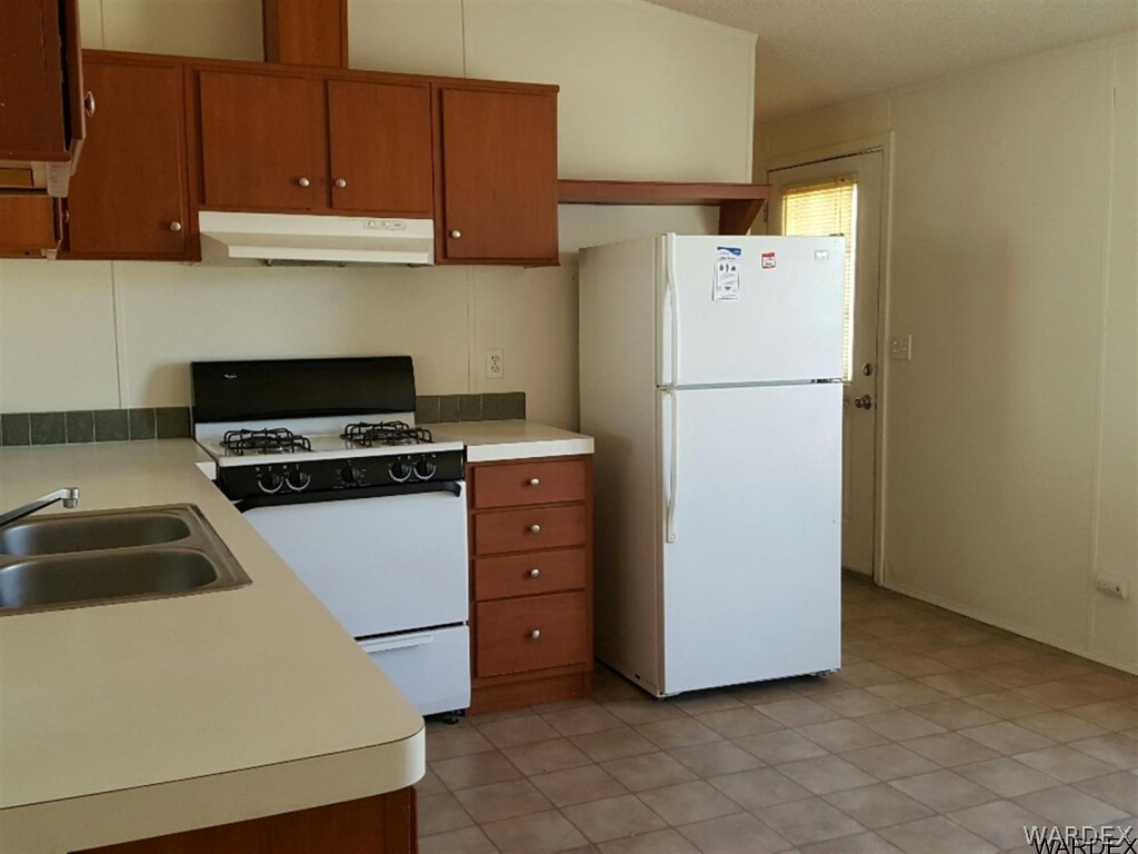 1097 South Concho Road Golden Valley, AZ 86413 - Photo 12 of 20 a kitchen with cabinets and white appliances