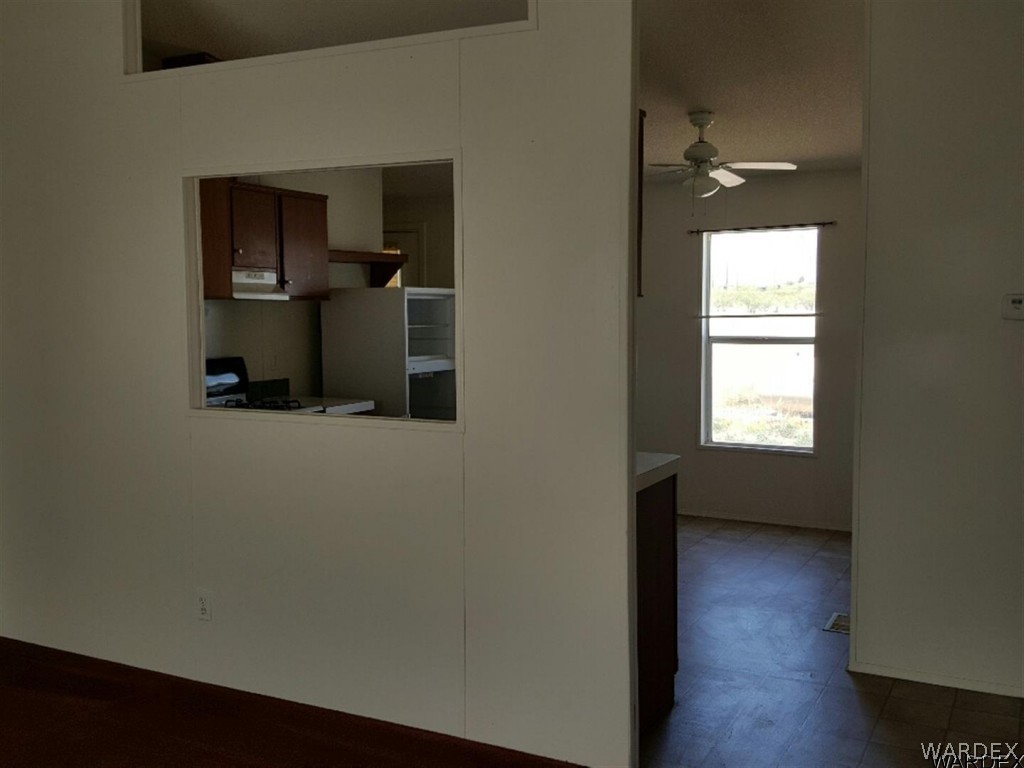 1097 South Concho Road Golden Valley, AZ 86413 - Photo 2 of 20 an empty room with wooden floor cabinet and windows