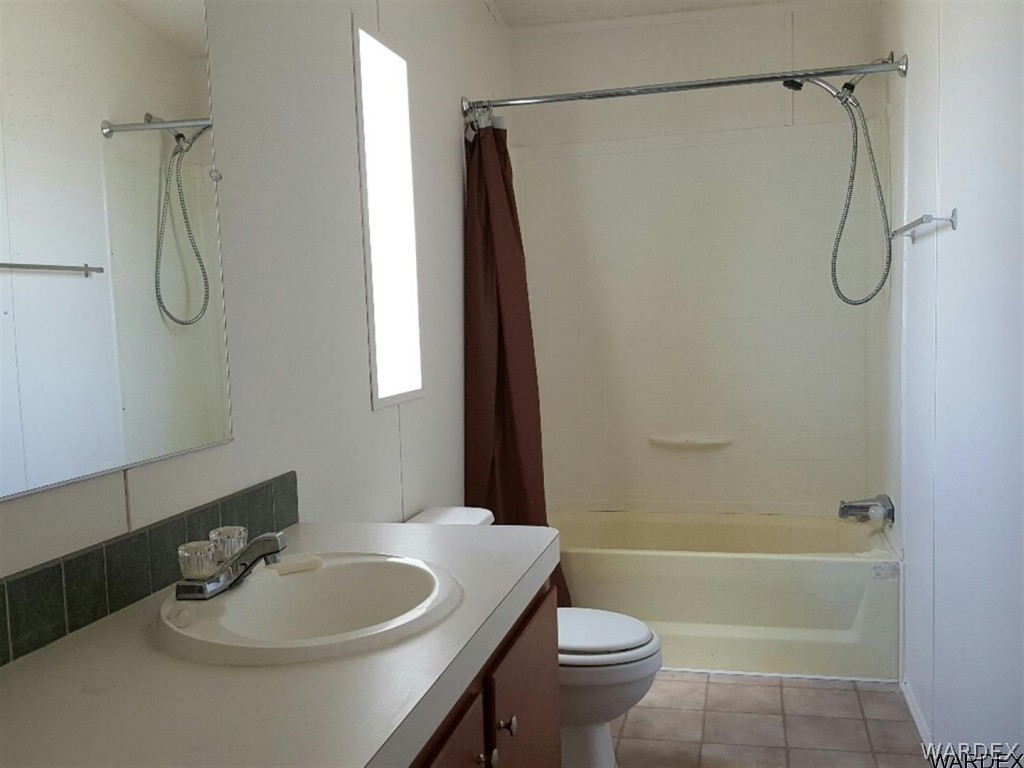 1097 South Concho Road Golden Valley, AZ 86413 - Photo 8 of 20 a bathroom with a sink a toilet and shower