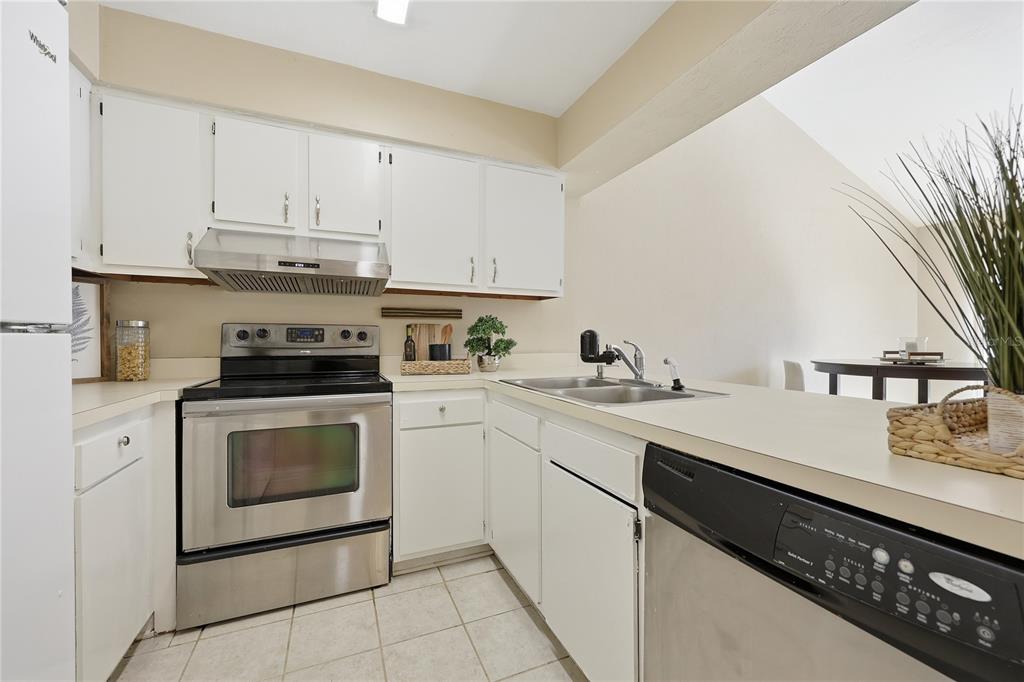 4427 Southwest 21st Lane Gainesville, FL 32607 - Photo 14 of 36 a kitchen with a sink white cabinets and white appliances